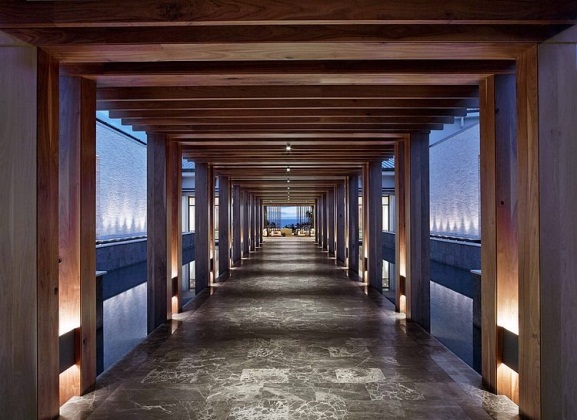 The abundant space and high ceilings are emphasised by the repetition of long wooden beams throughout the rooms and walkways, lending the resort a sense of grand tranquillity